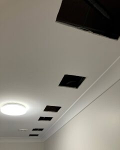 The Gyprock ceiling in the laundry, with more than five 20cm square holes